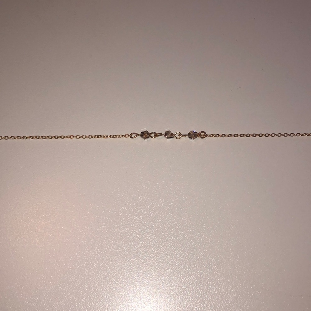 This is a gold necklace with white jewels